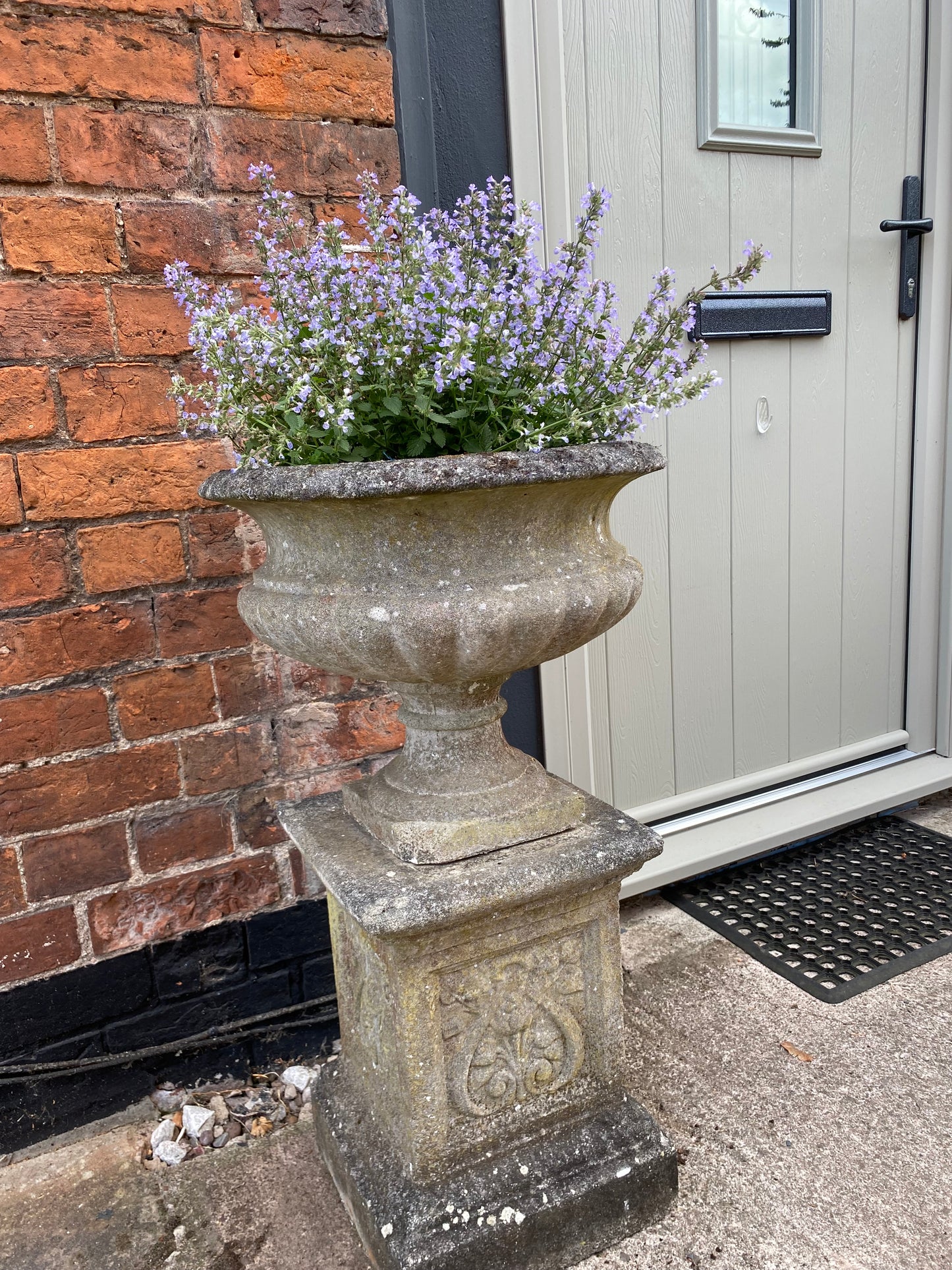 Decorative stone urn with a house in the background