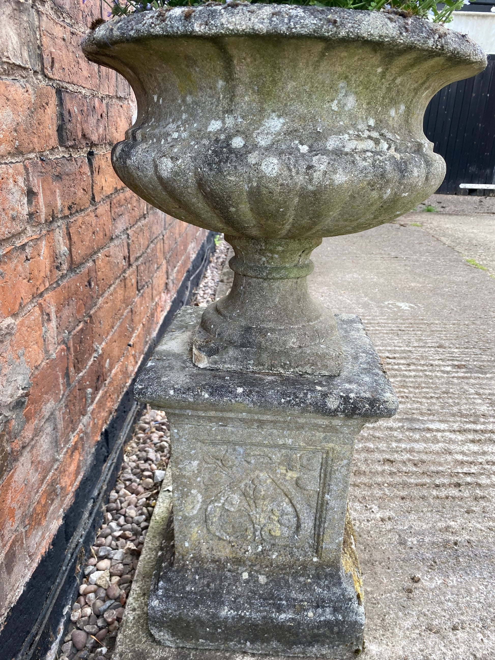 Side view of decorative stone urn showing weathering