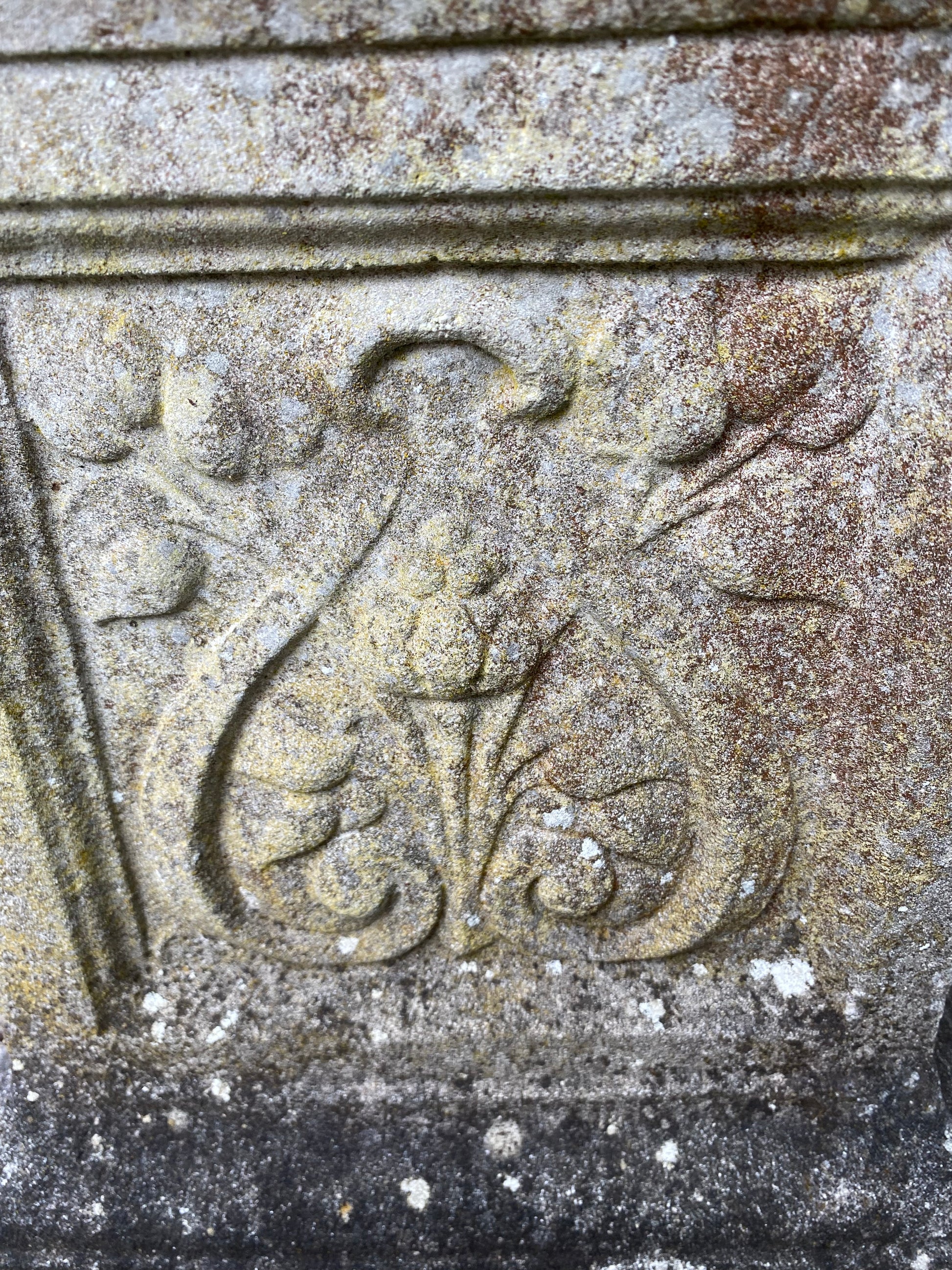 Close up of decorative stone scroll design on plinth for stone urn