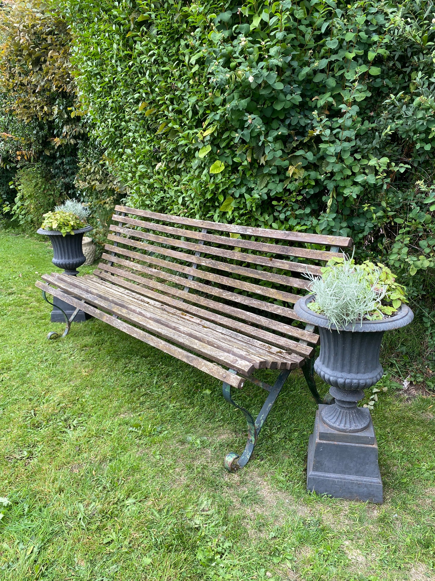 Vintage wrought iron framed garden bench with slatted seat and back